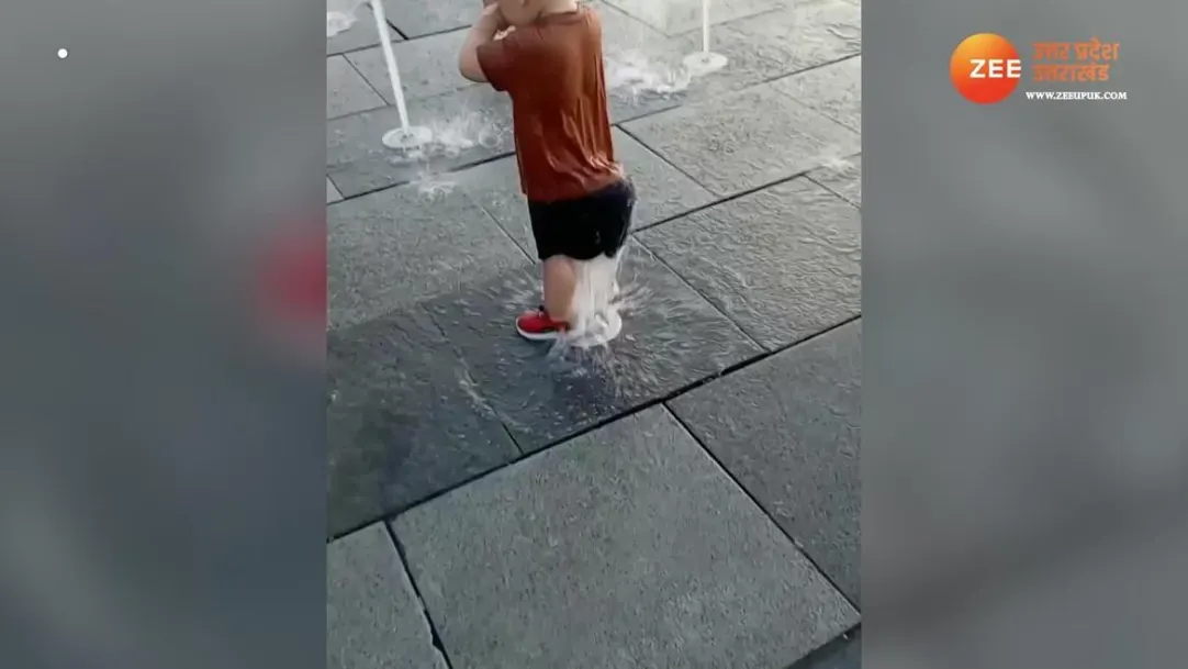 cute littel child enjoying fountain rain shower in unique way video viral 